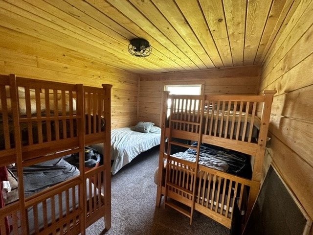 carpeted bedroom featuring wood ceiling and wooden walls