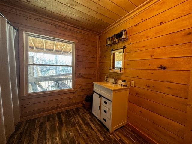 bathroom with wood-type flooring, wooden ceiling, wood walls, and vanity