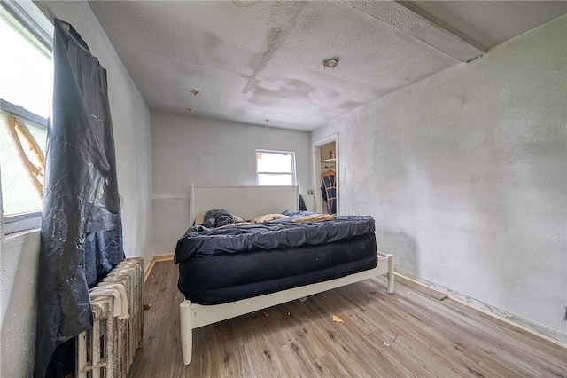 bedroom featuring wood-type flooring and a textured ceiling