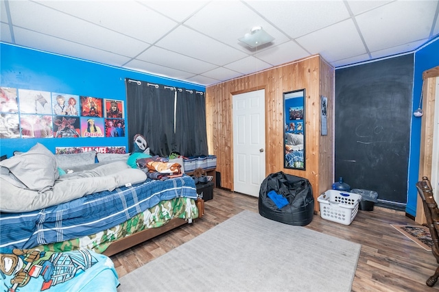 bedroom featuring a paneled ceiling and wood finished floors