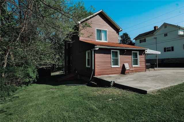 back of property featuring a patio and a lawn