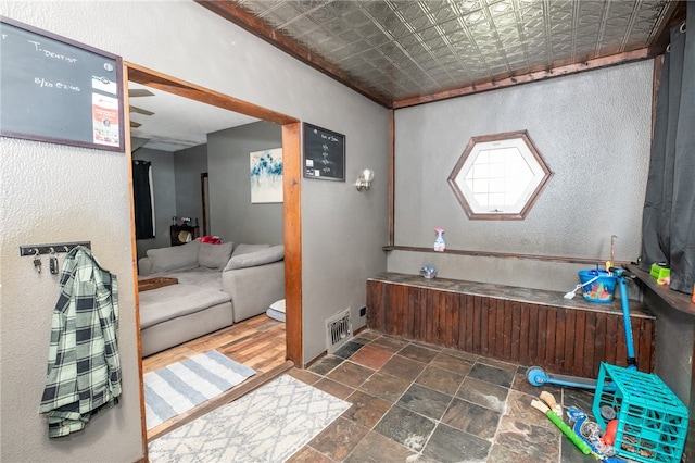 bathroom featuring visible vents, stone finish flooring, and an ornate ceiling