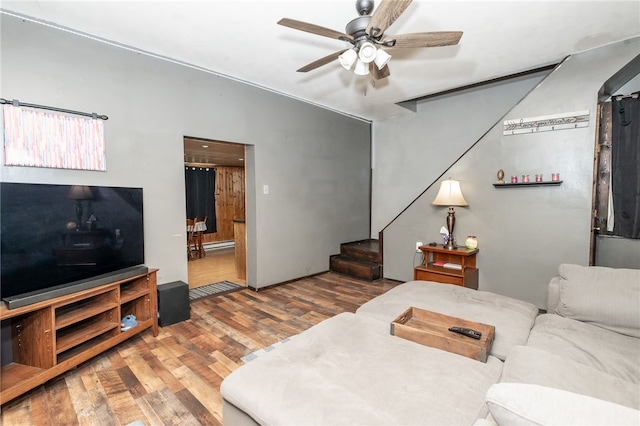 living area featuring ceiling fan, stairway, and wood finished floors