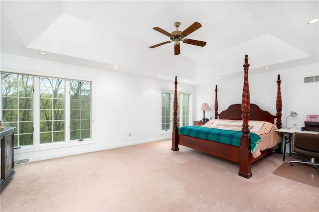 bedroom with ceiling fan, a tray ceiling, and carpet floors