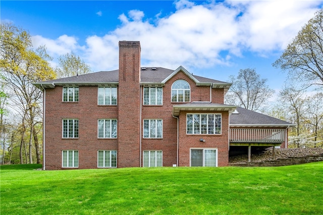 back of property featuring a wooden deck and a yard