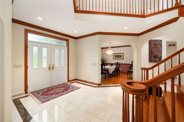 tiled foyer entrance featuring crown molding