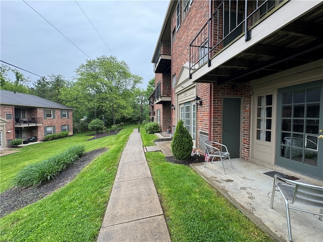 view of yard featuring a patio and a balcony