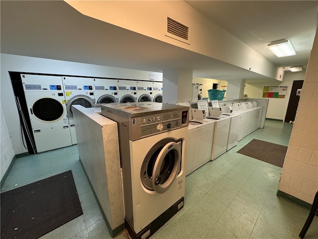 clothes washing area featuring separate washer and dryer and light tile floors