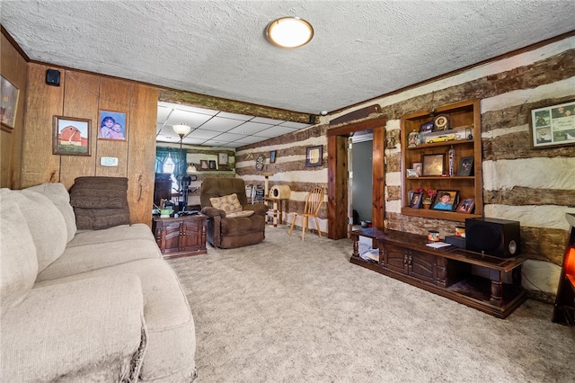 carpeted living room featuring wooden walls and a textured ceiling