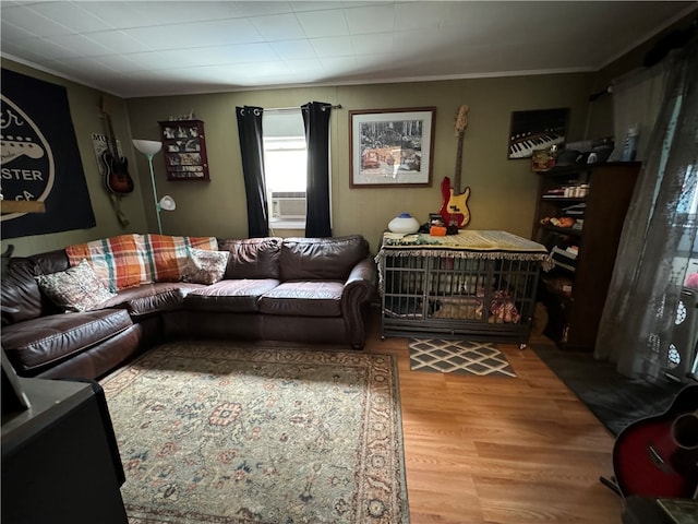 living room with crown molding, light hardwood / wood-style flooring, and cooling unit