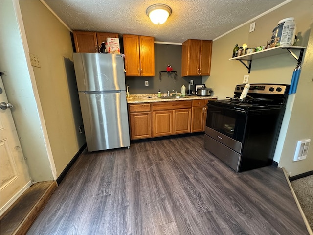 kitchen with a textured ceiling, crown molding, appliances with stainless steel finishes, and dark hardwood / wood-style flooring