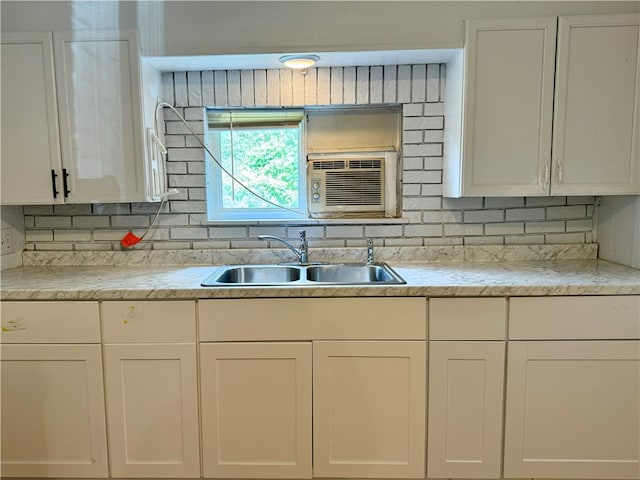 kitchen featuring cooling unit, sink, decorative backsplash, and white cabinetry