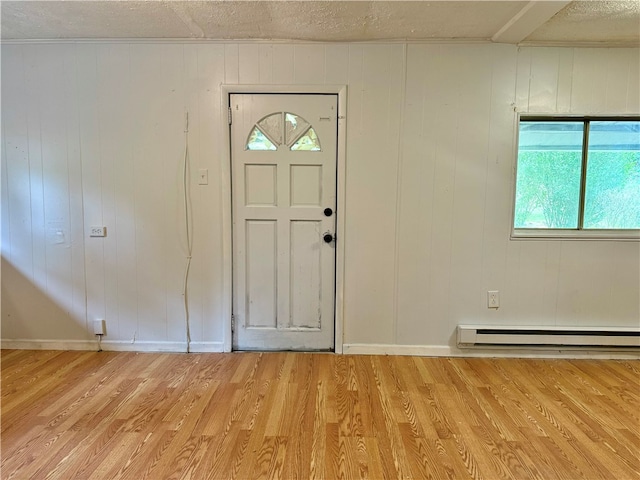 entrance foyer with light wood-type flooring, wood walls, and a baseboard radiator