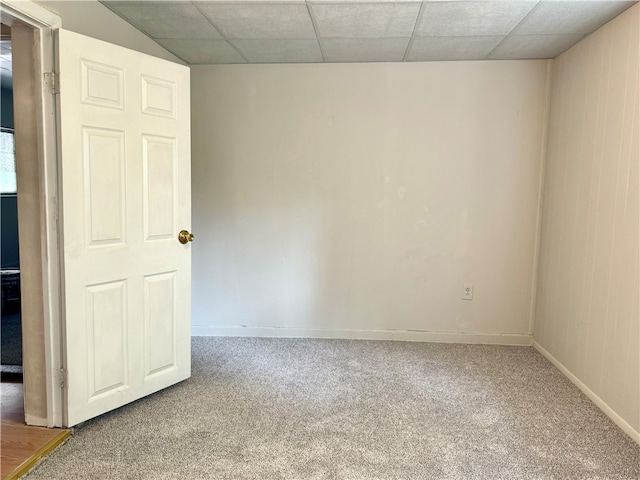 carpeted spare room with a paneled ceiling