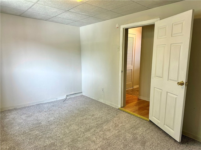 unfurnished bedroom with a paneled ceiling and carpet flooring