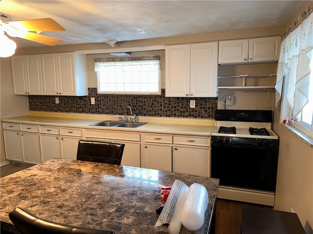 kitchen featuring white cabinets, sink, white range with gas stovetop, tasteful backsplash, and ceiling fan