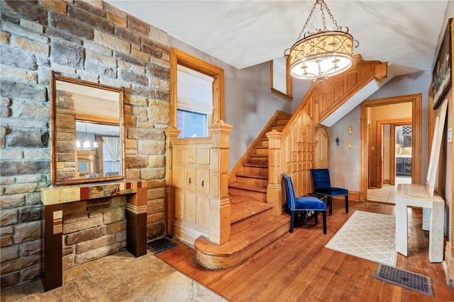 stairway with a notable chandelier and light tile flooring