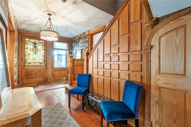 foyer with wooden walls and hardwood / wood-style floors