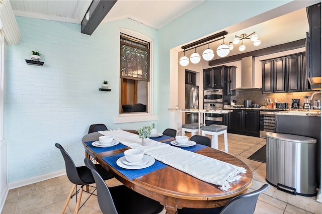 tiled dining area featuring ornamental molding and beamed ceiling