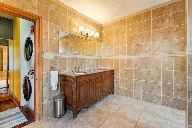 bathroom with tile walls, tile floors, and stacked washer / drying machine