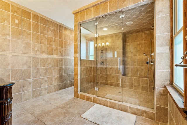 bathroom with tile floors, tile walls, and a shower with door