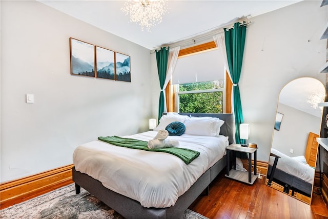 bedroom with wood-type flooring and a chandelier