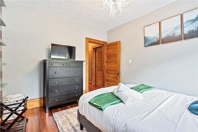 bedroom with dark hardwood / wood-style flooring and a notable chandelier