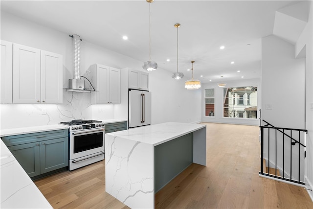 kitchen featuring gas range oven, tasteful backsplash, decorative light fixtures, high end fridge, and light hardwood / wood-style flooring