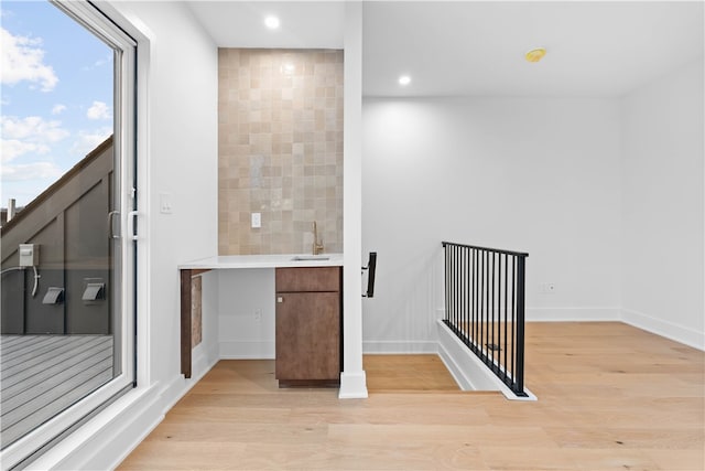 staircase with sink and light wood-type flooring