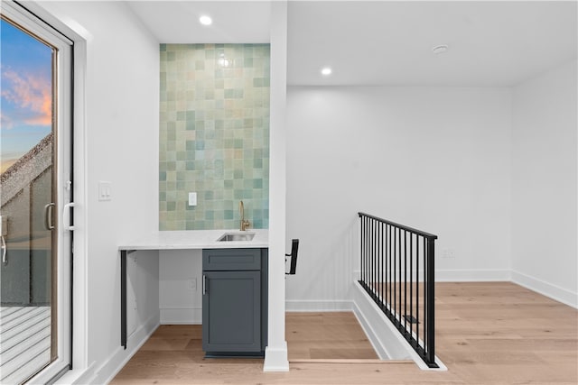 interior space featuring sink, light hardwood / wood-style flooring, backsplash, and gray cabinetry