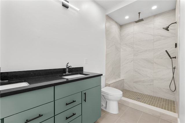 bathroom with tile floors, double vanity, toilet, and a tile shower