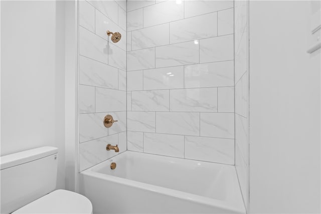 bathroom with tiled shower / bath combo and toilet