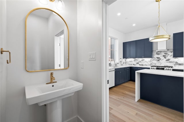 bathroom with wood-type flooring, backsplash, and sink