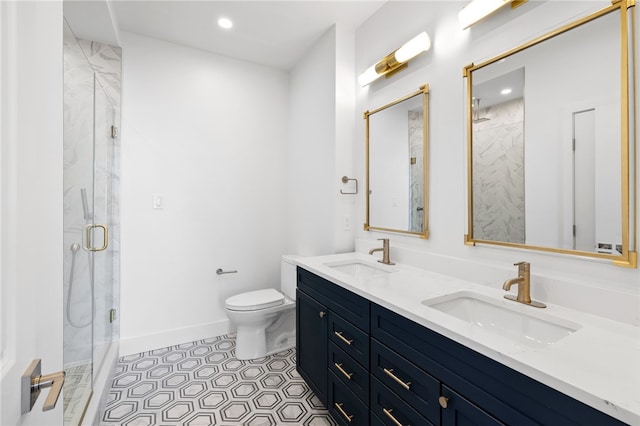 bathroom featuring a shower with shower door, toilet, dual vanity, and tile flooring