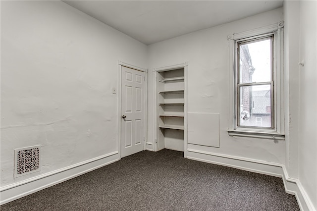 empty room featuring dark colored carpet