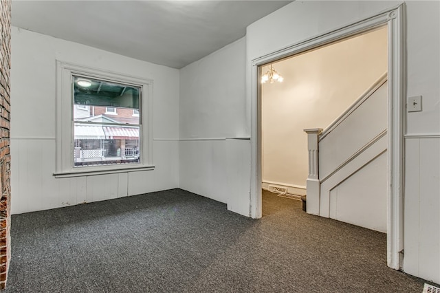 spare room with dark colored carpet