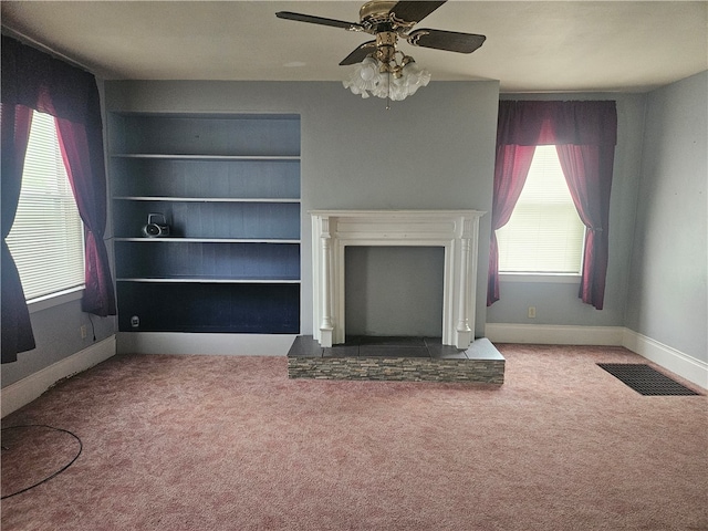 unfurnished living room featuring ceiling fan and carpet floors