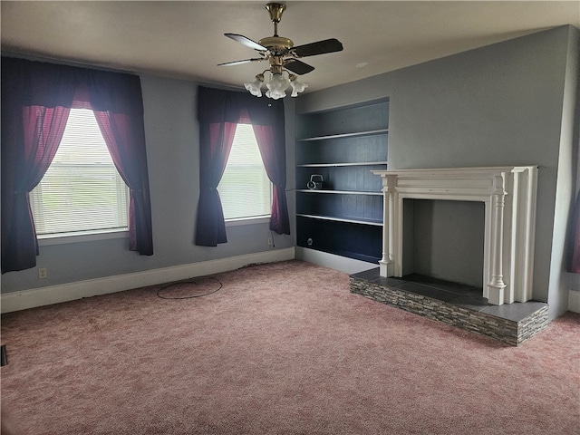 unfurnished living room with built in features, carpet, and ceiling fan