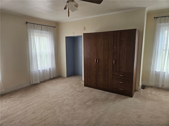 unfurnished bedroom with light carpet and ceiling fan