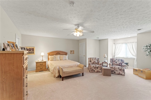 carpeted bedroom featuring a textured ceiling and ceiling fan