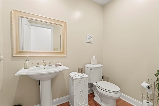 bathroom featuring hardwood / wood-style flooring and toilet