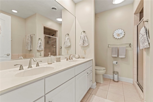 bathroom featuring tile patterned floors, walk in shower, vanity, and toilet