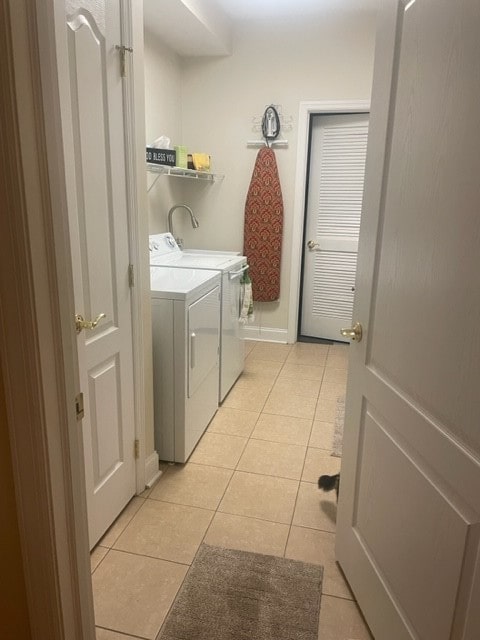 laundry area with separate washer and dryer and light tile patterned flooring