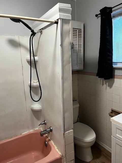 full bathroom featuring tile walls, toilet, shower / bathing tub combination, and vanity