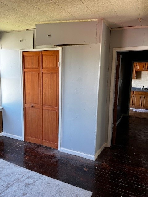 unfurnished bedroom with dark hardwood / wood-style floors and sink