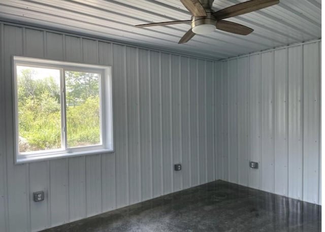 empty room featuring ceiling fan and concrete flooring