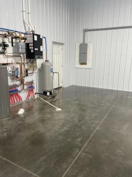 garage with water heater, metal wall, and electric panel