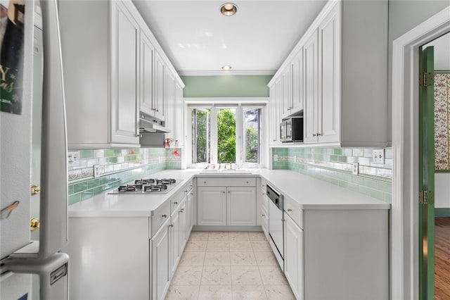 kitchen with white cabinets, crown molding, stainless steel appliances, sink, and tasteful backsplash