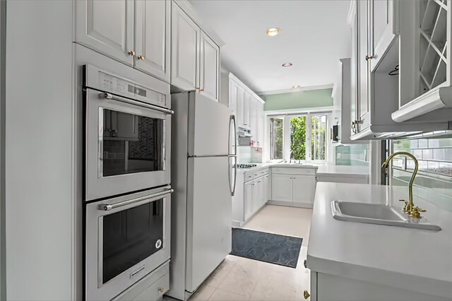 kitchen with sink, appliances with stainless steel finishes, and white cabinets