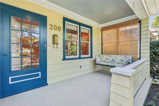 view of exterior entry featuring covered porch